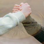 Grasping each other arms to show trust and support
